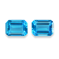 Loose matched pair of emerald-cut blue topaz.  These lively octagon swiss blue topaz pair are very clean and have a ton of life. These November birthstones would be beautiful as earrings or as a nice accent side stones.