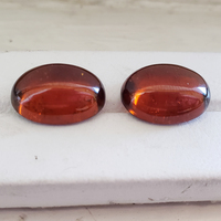 Large 20+ carats untreated oval cabochon amber orange zircon pair.  This clean pair of zircons has beautiful golden flashes with orange and sienna undertones. Big, bold and beautiful pair of zircon cabs.
