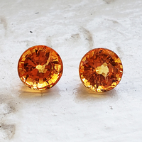 Matching pair of round  golden orange yellow sapphires. This pair of 5 mm+ mandarin golden  sapphires are clean and lively.